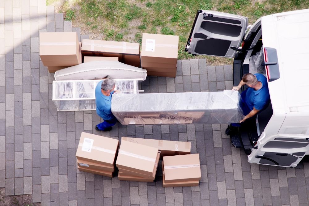 Two men are unloading boxes from a van in an indoor junk removal service location in Springfield, IL.