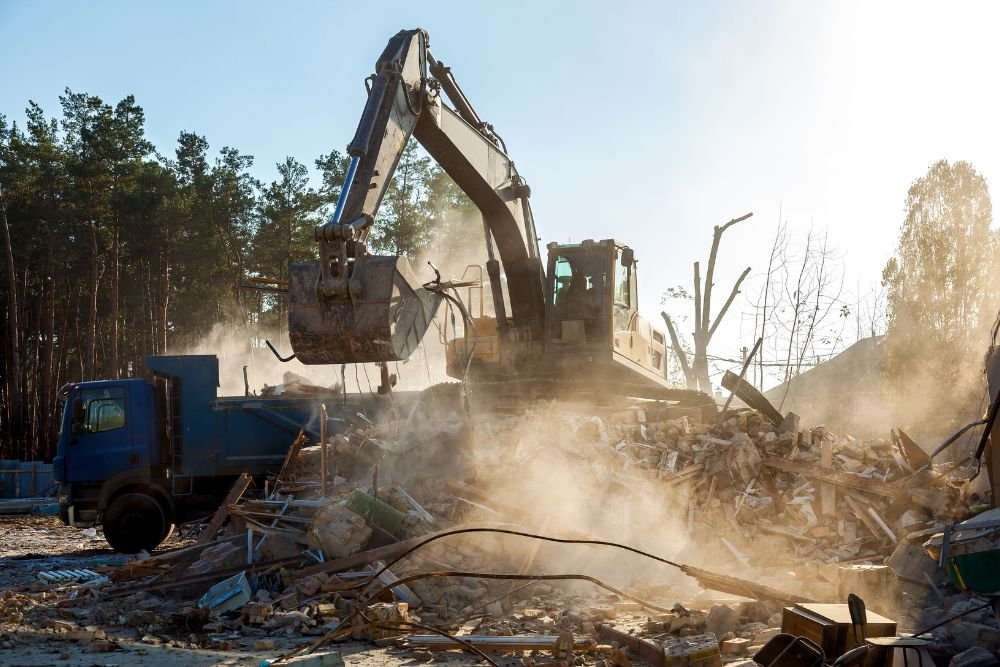 A large excavator operates on a pile of rubble at a construction site in Springfield, IL, indicating renovation work.