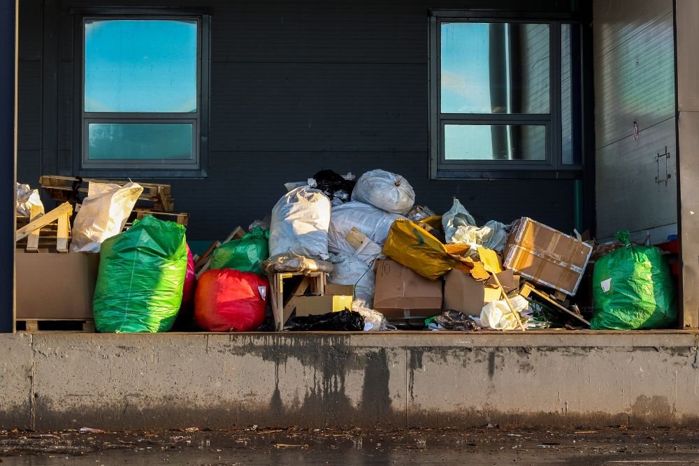 Overflowing garbage bags and various items outside a building, representing a junk removal service in Springfield, IL.