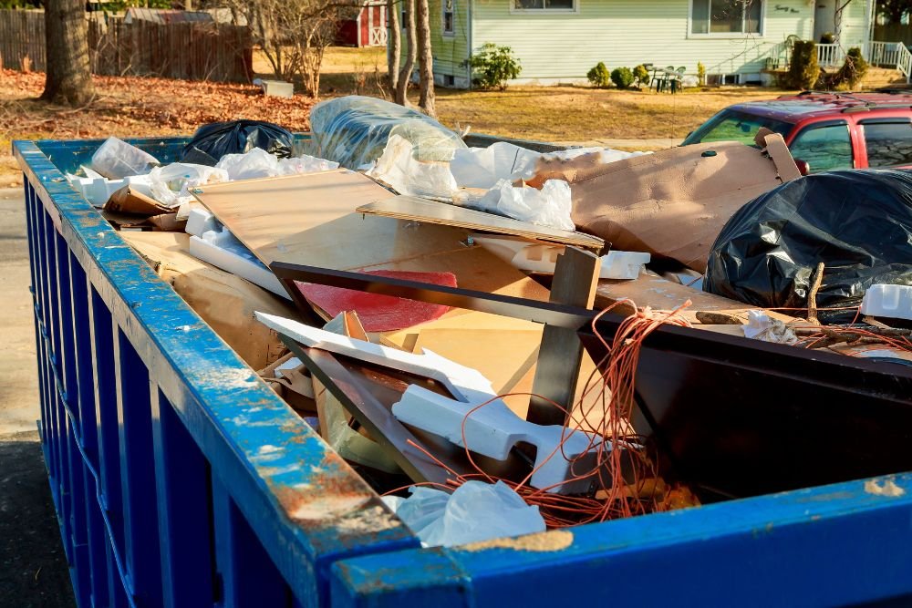 A blue dumpster packed with debris, showcasing bulk junk removal services available in Springfield, IL.